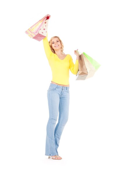 femme heureuse avec des sacs à provisions sur mur blanc