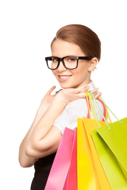 femme heureuse avec des sacs à provisions sur mur blanc