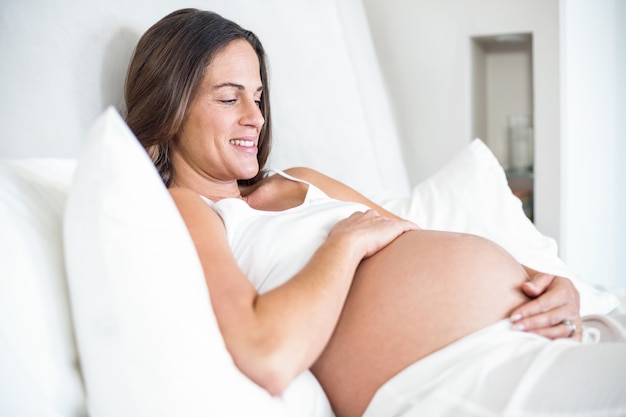 Femme heureuse se détendre sur le lit