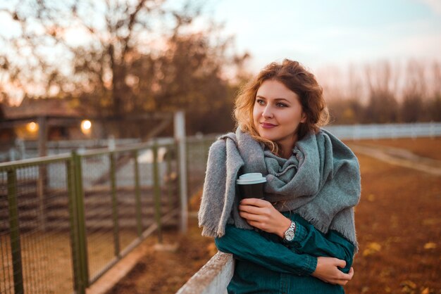 Femme heureuse se réchauffer avec un café chaud au froid matin d&#39;automne.