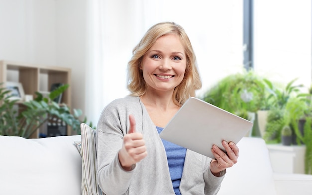 femme heureuse avec une tablette montrant les pouces en l'air