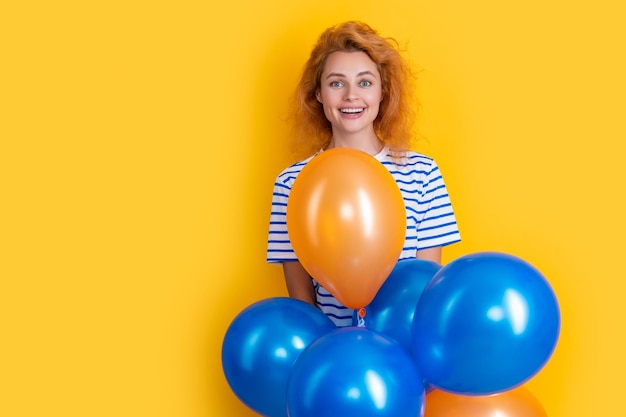 Femme heureuse tenir des ballons de fête en studio copie espace femme avec ballon pour fête isolé sur fond jaune