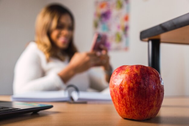 Femme heureuse utilisant son téléphone travaillant à domicile.