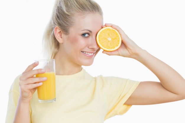 Femme heureuse avec un verre de jus et une tranche d&#39;orange