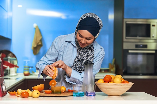 Femme hijab arabe faisant du jus de fruits dans une cuisine moderne Concept de maison Concept de mode de vie sain Mise au point sélective Photo de haute qualité