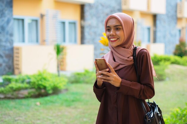 Photo une femme en hijab avec un cahier à la main