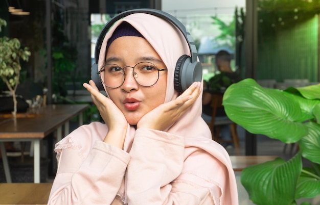 La femme de Hijab écoute la musique par des écouteurs