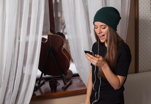 Femme hipster au chapeau vert écoutant de la musique et profitant de la vie