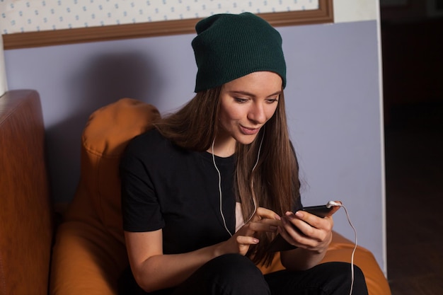 Femme hipster écoutant de la musique au café