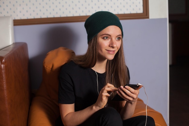 Femme hipster écoutant de la musique au café