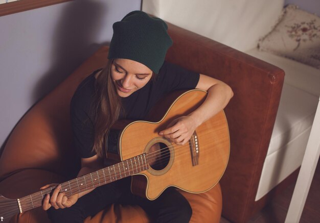 Femme hipster jouant de la guitare et appréciant la musique