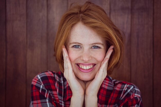 femme hipster souriante avec ses mains sur son visage