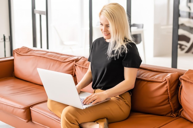 Une femme hipster utilise un ordinateur portable immense Loft Studio. Travail de processus de recherche étudiant. Jeune femme d'affaires travaillant au bureau moderne de démarrage créatif. Analyser les actions du marché, nouvelle stratégie.