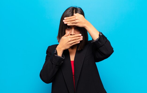 Femme hispanique couvrant le visage avec les deux mains en disant non à la caméra! refuser les photos ou interdire les photos