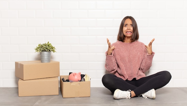 Femme hispanique criant avec les mains en l'air, se sentant furieuse, frustrée, stressée et bouleversée