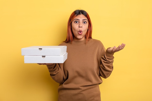 Une femme hispanique étonnée, choquée et étonnée par une incroyable surprise à emporter concept de pizzas