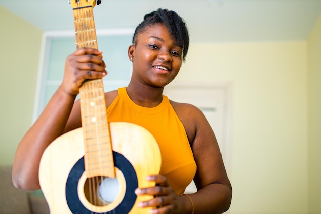 Photo femme hispanique latine apprenant à jouer de la guitare