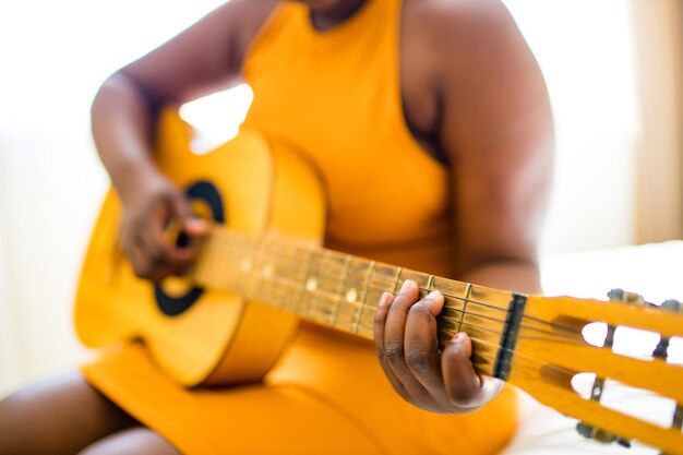 Femme hispanique latine apprenant à jouer de la guitare