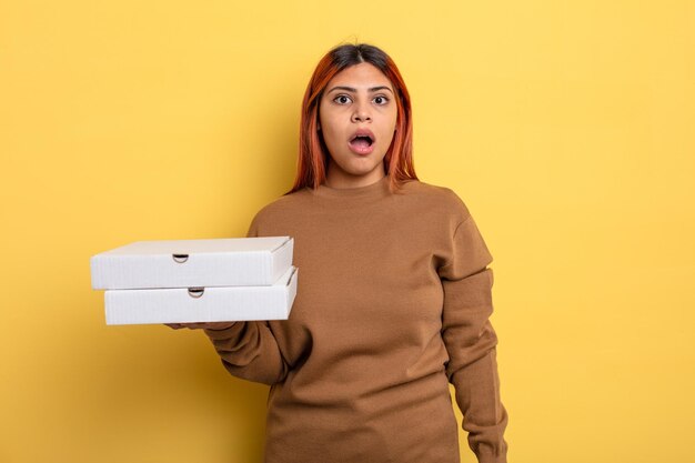 femme hispanique qui a l'air très choquée ou surprise. concept de pizzas à emporter