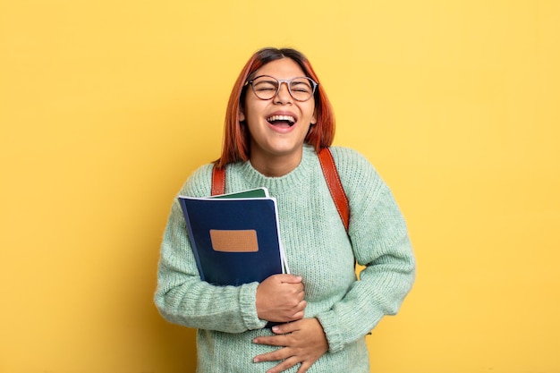 Femme hispanique riant à haute voix à une blague hilarante. notion d'étudiant