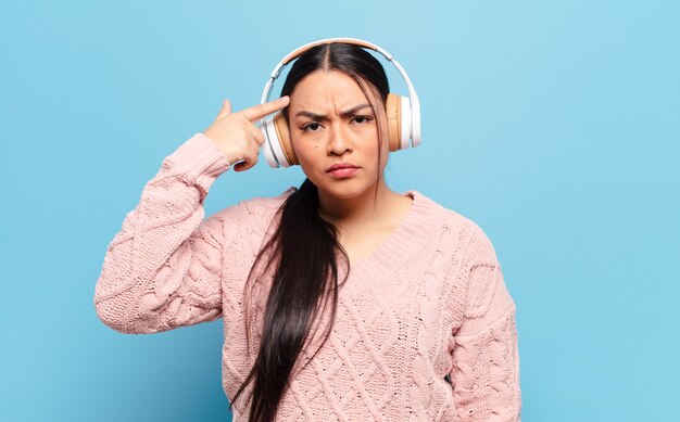 Femme hispanique se sentant confuse et perplexe, montrant que vous êtes folle, folle ou folle