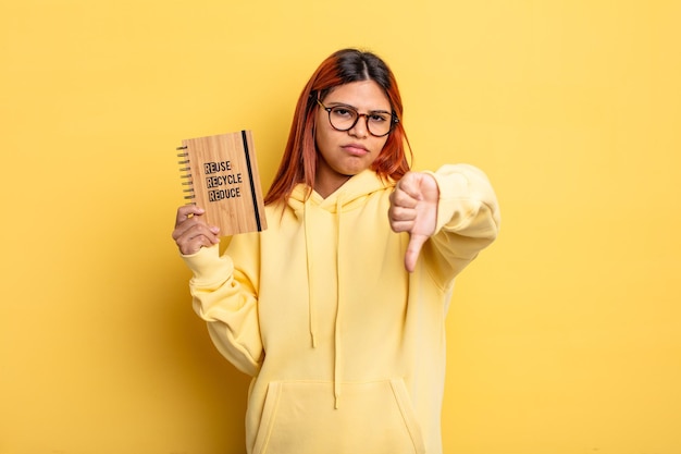 femme hispanique se sentant croisée, montrant les pouces vers le bas. concept de recyclage