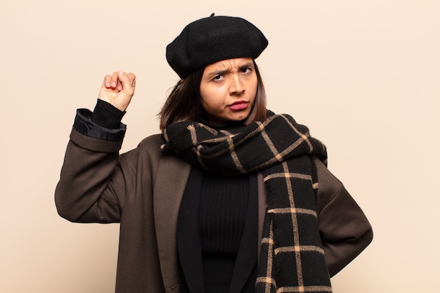 Photo femme hispanique se sentant sérieuse, forte et rebelle, levant le poing, protestant ou luttant pour la révolution