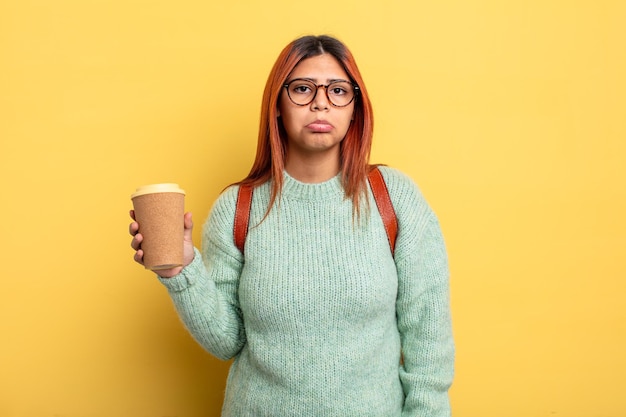 Femme hispanique se sentant triste et geignarde avec un regard malheureux et une étudiante en pleurs avec un concept de café