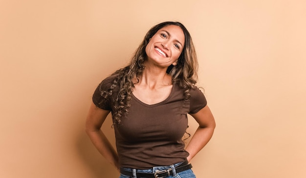 Une femme hispanique se tient debout et sourit à la caméra.