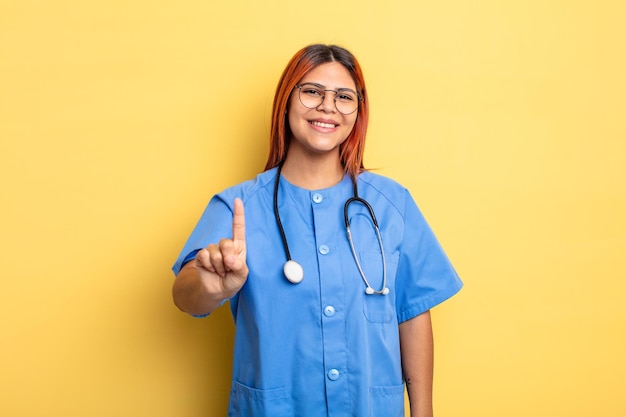 femme hispanique souriante et sympathique, montrant le numéro un. notion d'infirmière