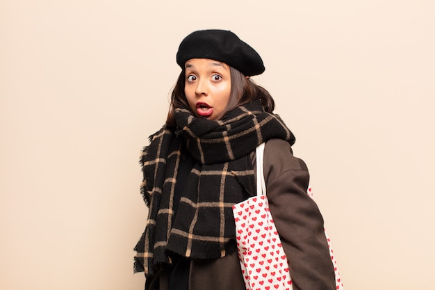 Femme hispanique à très choqué ou surpris, regardant la bouche ouverte en disant wow