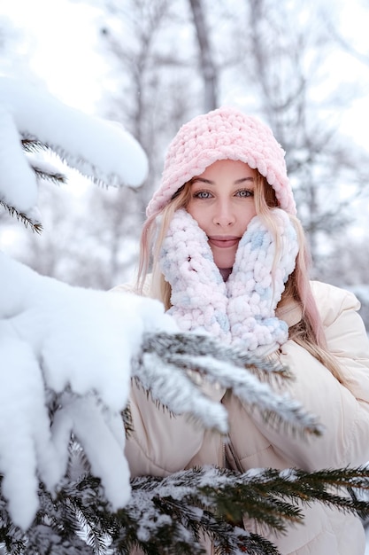 Femme d'hiver dans la neige regardant la caméra à l'extérieur sur la neige froide journée d'hiver Portrait modèle féminin de race blanche à l'extérieur dans la première neige