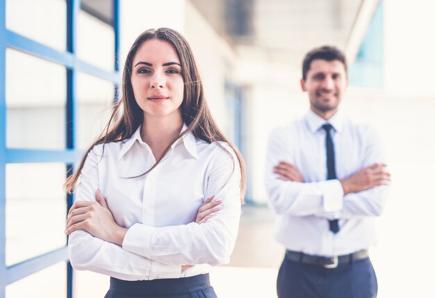 La femme et l'homme d'affaires se tiennent près de la fenêtre