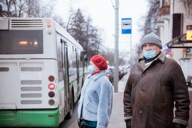 Femme et homme âgé portant des masques médicaux de protection dans la rue