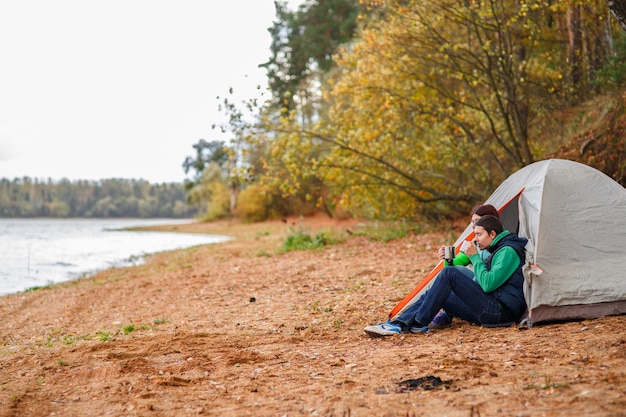 Femme et homme assis près de la tente