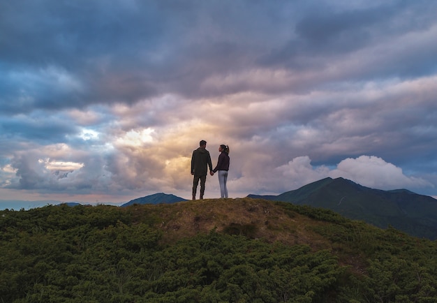 La femme et l'homme debout sur la montagne