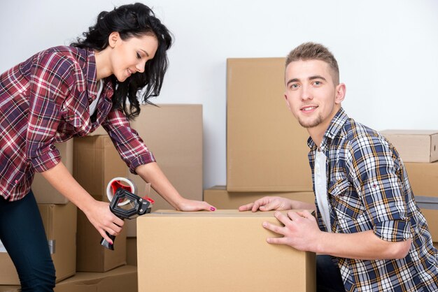 Une femme et un homme emballent des boîtes pendant leur déménagement.