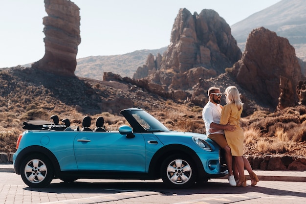 Une femme et un homme portant des lunettes dans une voiture décapotable lors d'un voyage sur l'île de Tenerife. Le cratère du volcan Teide, îles Canaries, Espagne.