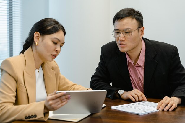 Photo une femme et un homme regardent un ordinateur portable