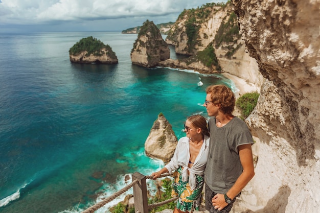 Une femme et un homme se tiennent à la plage de diamant sur l'île de Nusa Penida