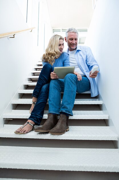 Femme avec homme tenant une tablette numérique