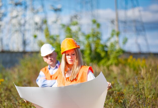 Femme et homme travaillant comme architectes sur un chantier de construction