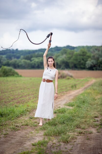 Photo une femme hongroise debout sur le terrain dans une robe en lin avec un fouet