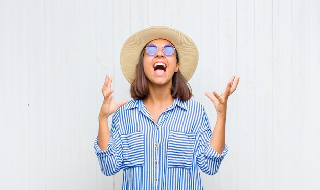 Femme hurlant furieusement, se sentant stressée et agacée avec les mains en l'air en disant pourquoi moi