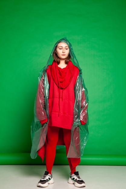 Photo femme en imperméable debout en studio sur fond vert