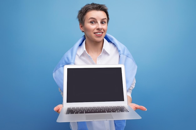 Femme indépendante élégante et confiante avec une maquette d'ordinateur portable sur fond de studio