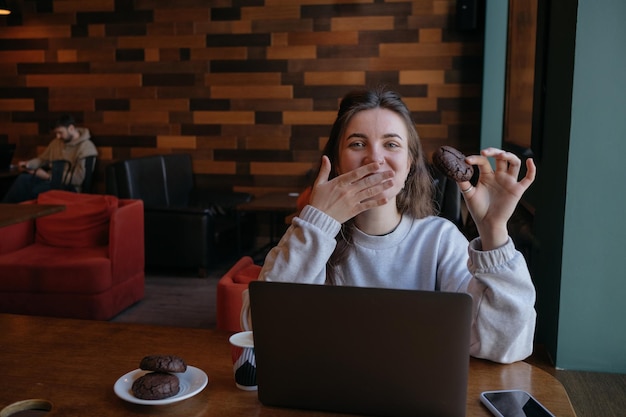 Femme indépendante heureuse de travailler dans un café à distance