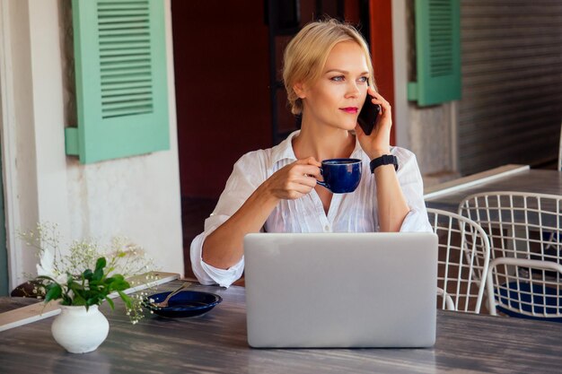 Femme indépendante indépendante avec ordinateur portable sur la plage assis dans un café d'été .business lady travail à distance surfeur surfant sur le navigateur en ligne.