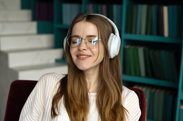 Femme indépendante avec des lunettes prend une pause en écoutant de la musique avec des écouteurs