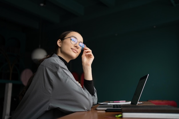 Une femme indépendante travaille dans un bureau utilise l'espace de coworking sur le lieu de travail de l'ordinateur portable Internet